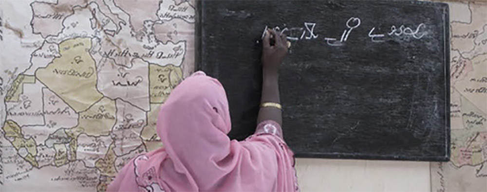 A woman writing on a chalkboard